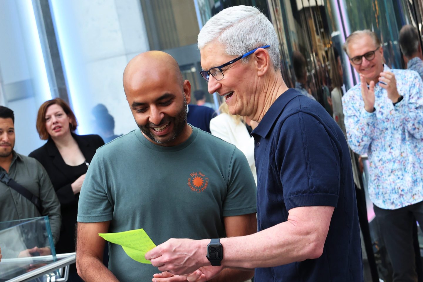 Tim Cook talking with a customer in front of an Apple Store.