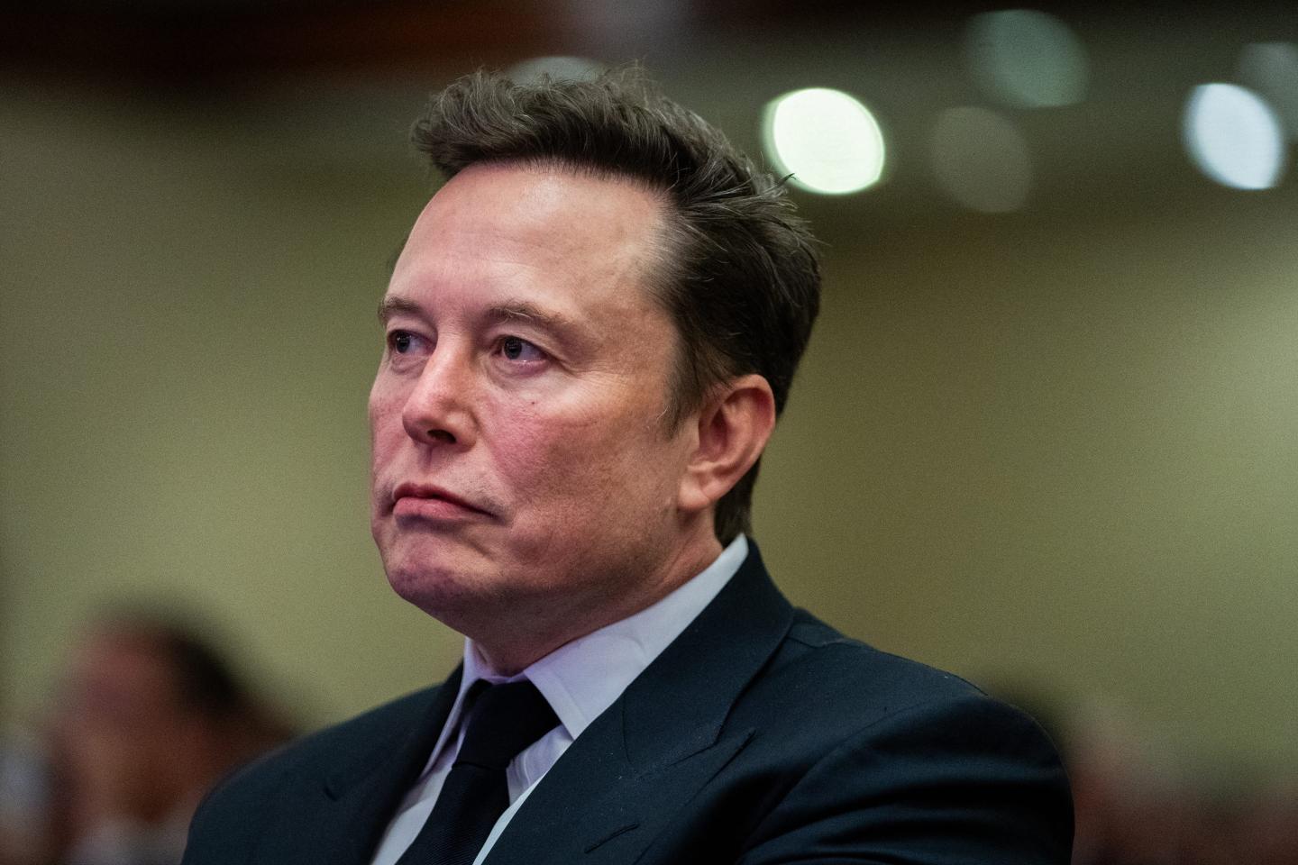 Elon Musk listens as US President-elect Donald Trump speaks during a meeting with House Republicans at the Hyatt Regency hotel in Washington, DC on November 13, 2024.