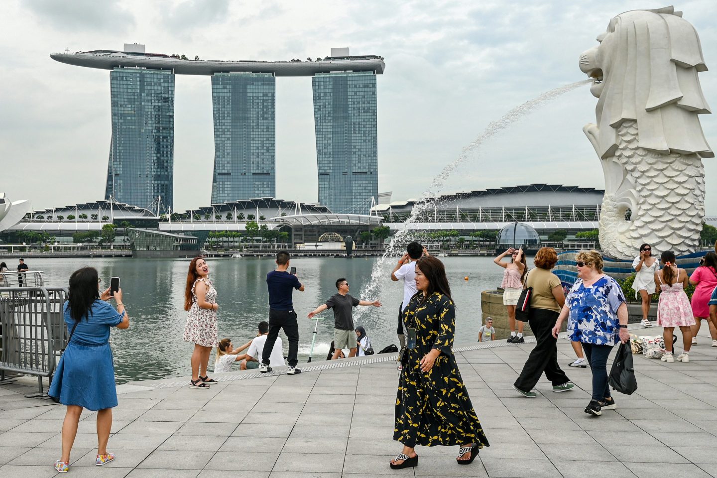 People gather near the Merlion statue in front of the Marina Bay Sands resort in Singapore on Dec. 2, 2024.