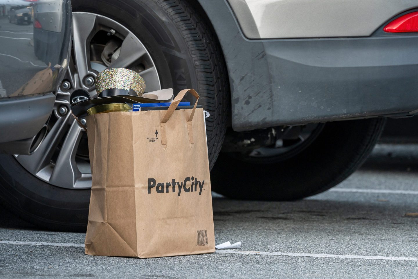 A Party City shopping bag in a parking lot