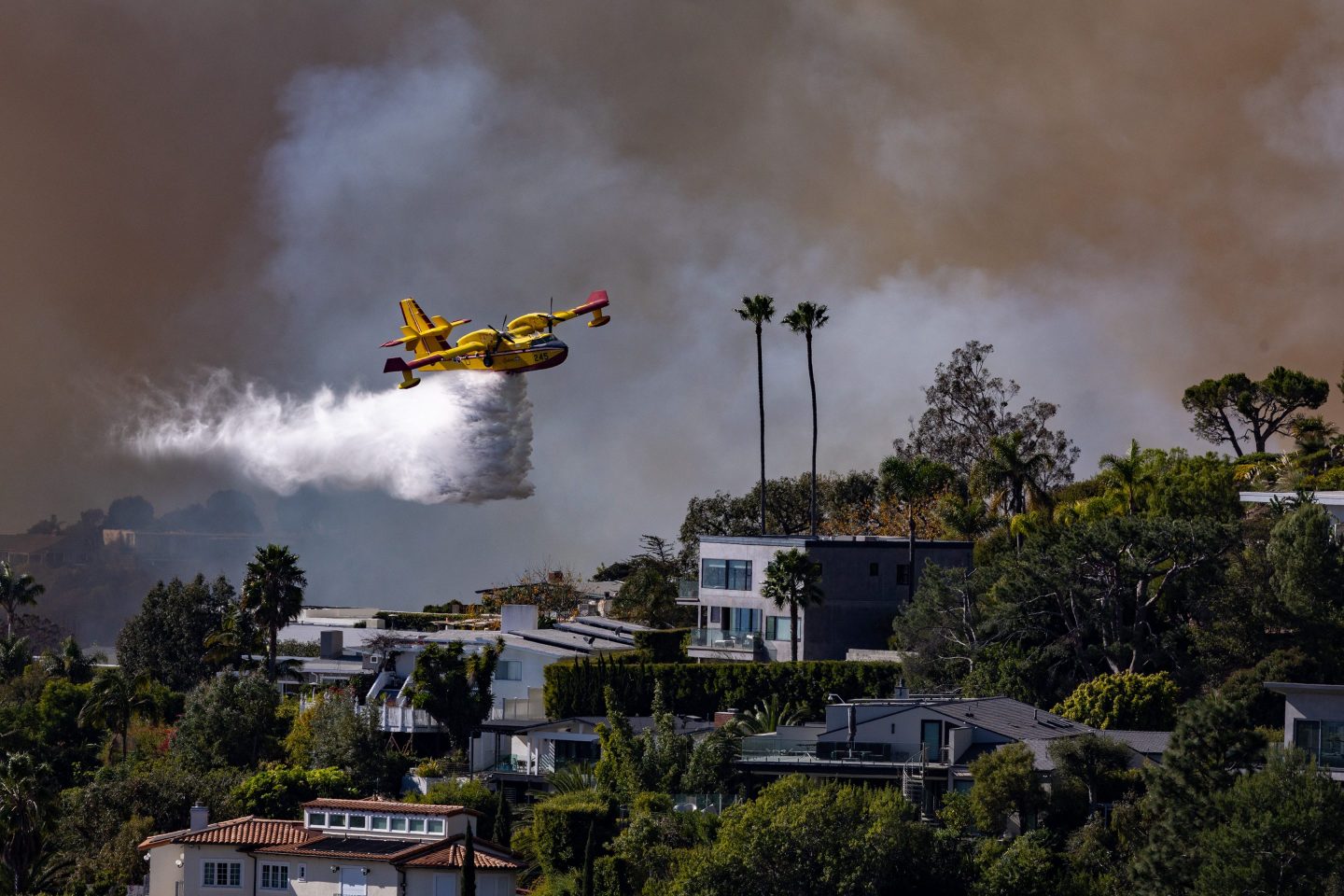 A Super SCooper plane drops water on the Palisades fire on Tuesday.