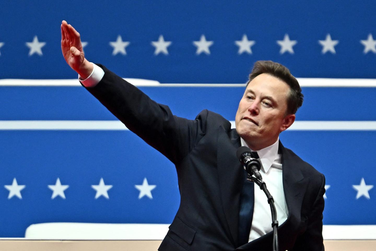 Elon Musk gestures as he speaks during the inaugural parade