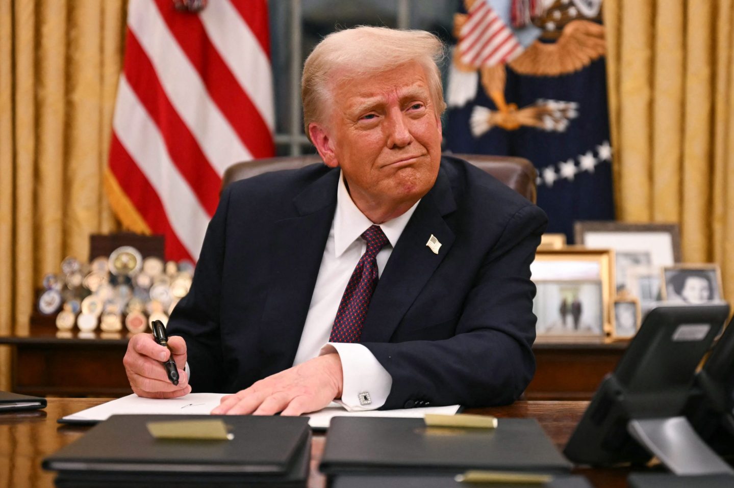 US President Donald Trump signs executive orders in the Oval Office of the White House