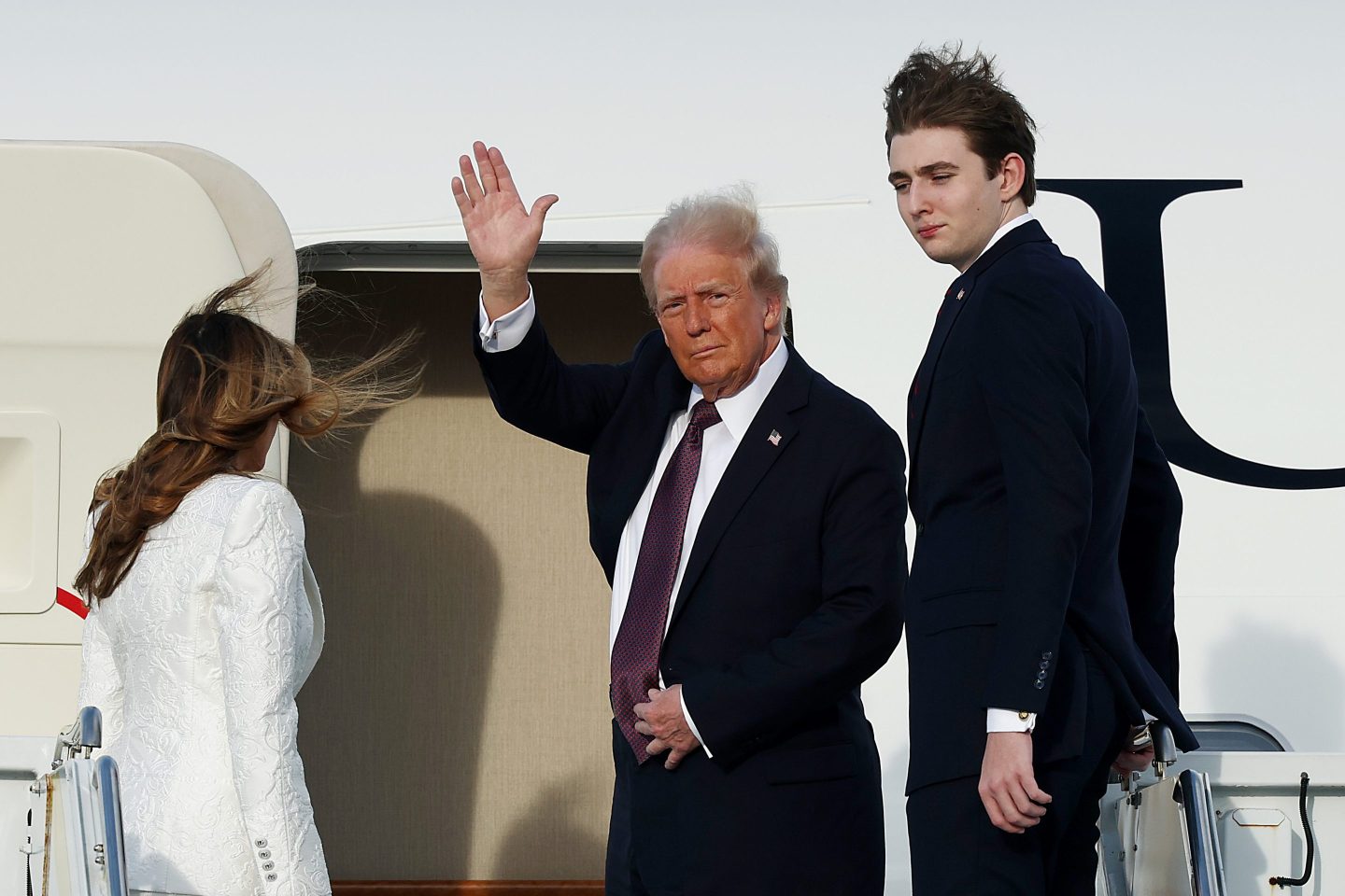 Donald Trump, Melania Trump and their son Barron board a U.S. Air Force aircraft Saturday in West Palm Beach, Florida.