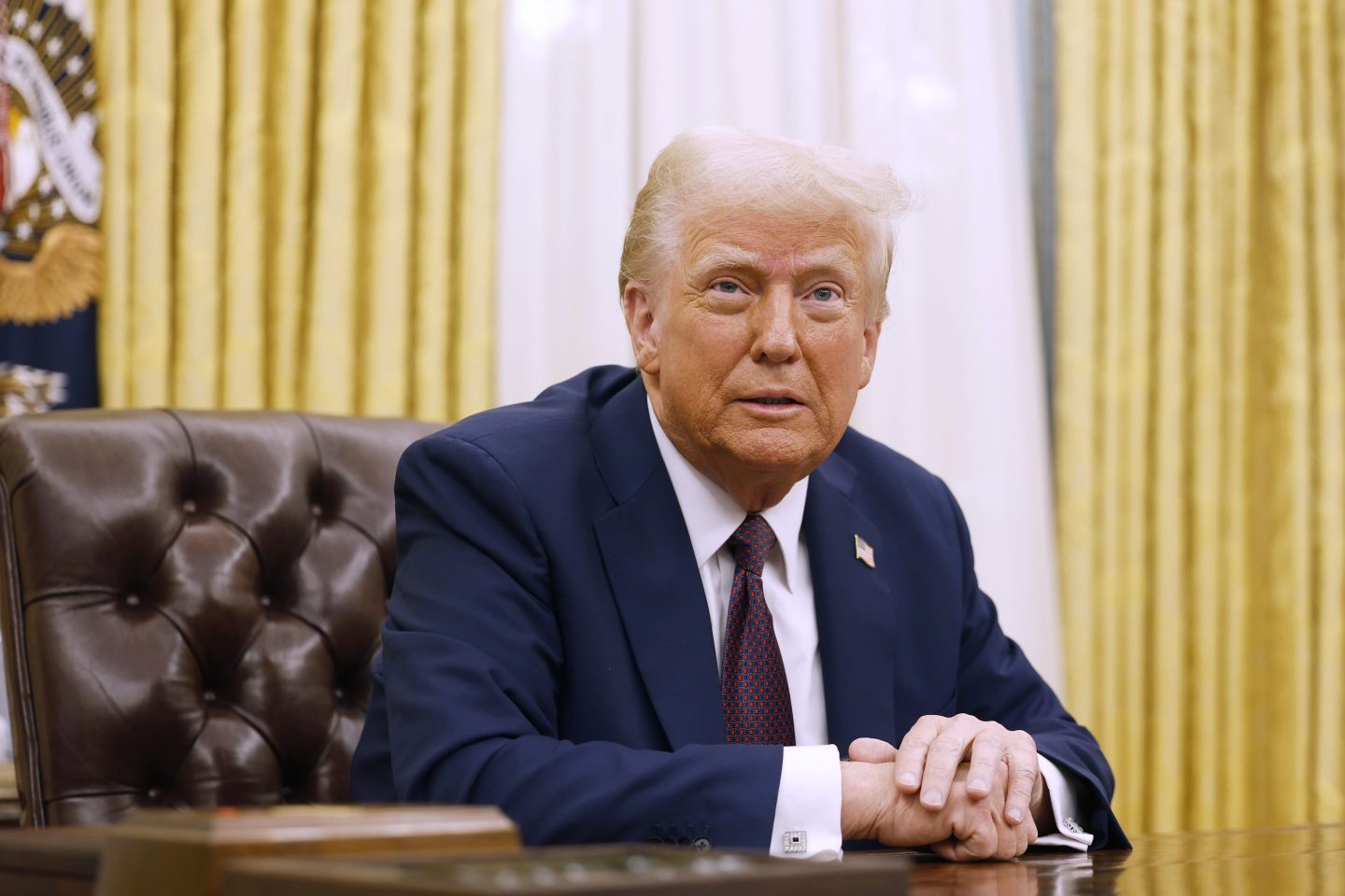 President Donald Trump sitting at a desk in the Oval Office