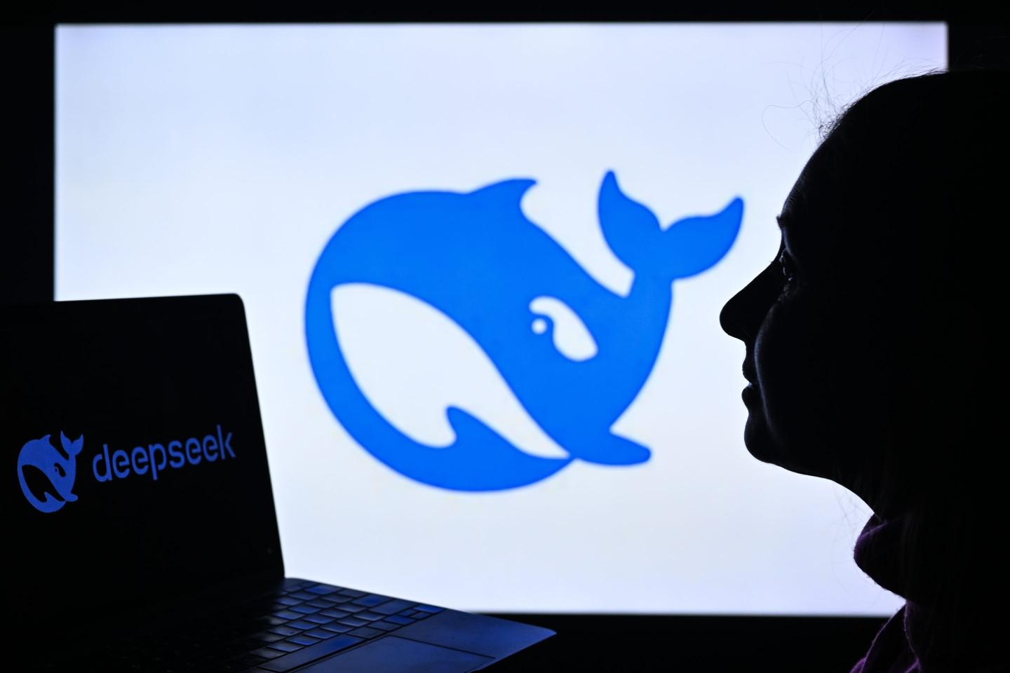 A woman looks at a laptop with the DeepSeek logo and the same whale icon is displayed in the background.