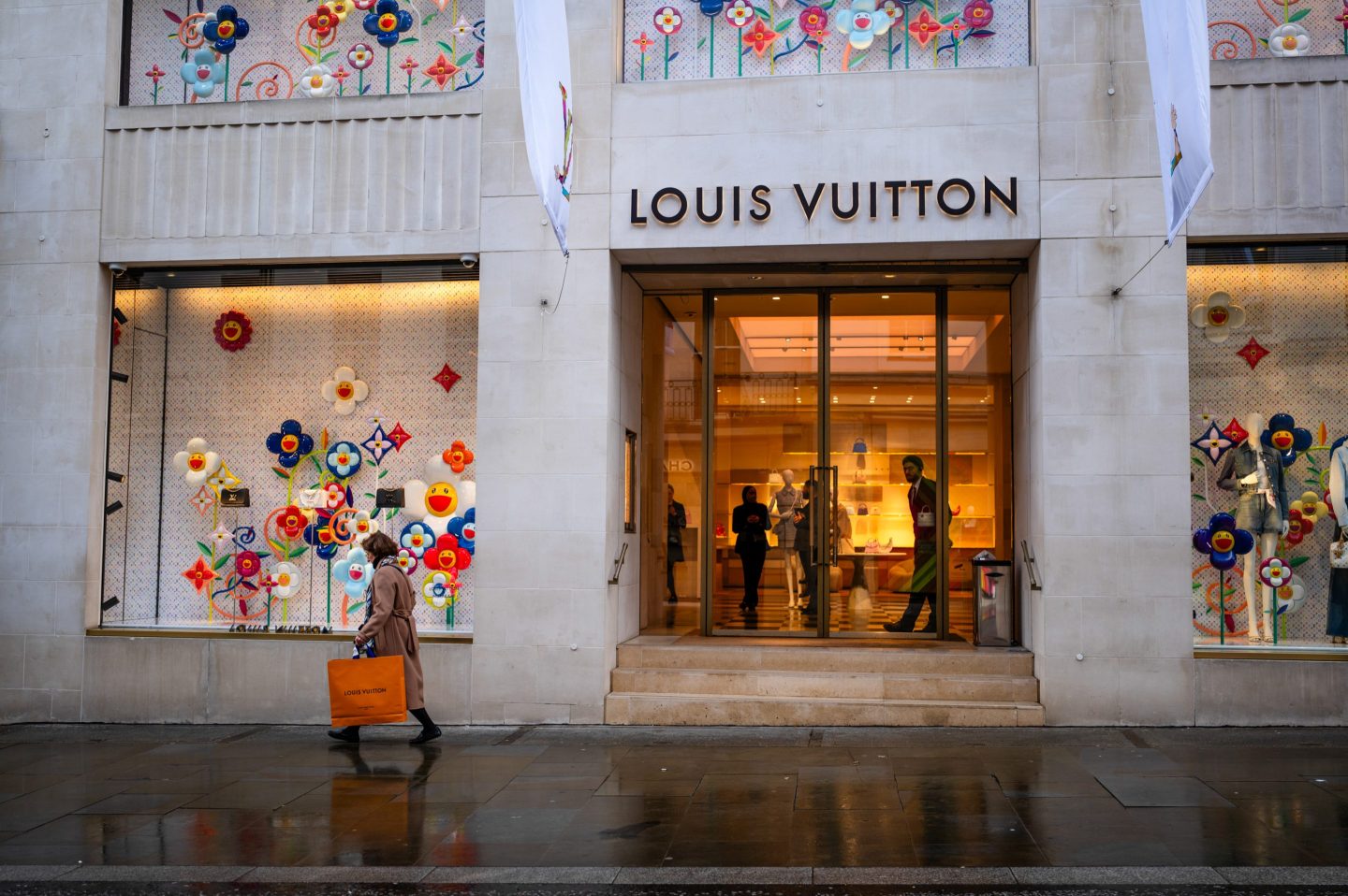 person walking outside a louis vuitton store
