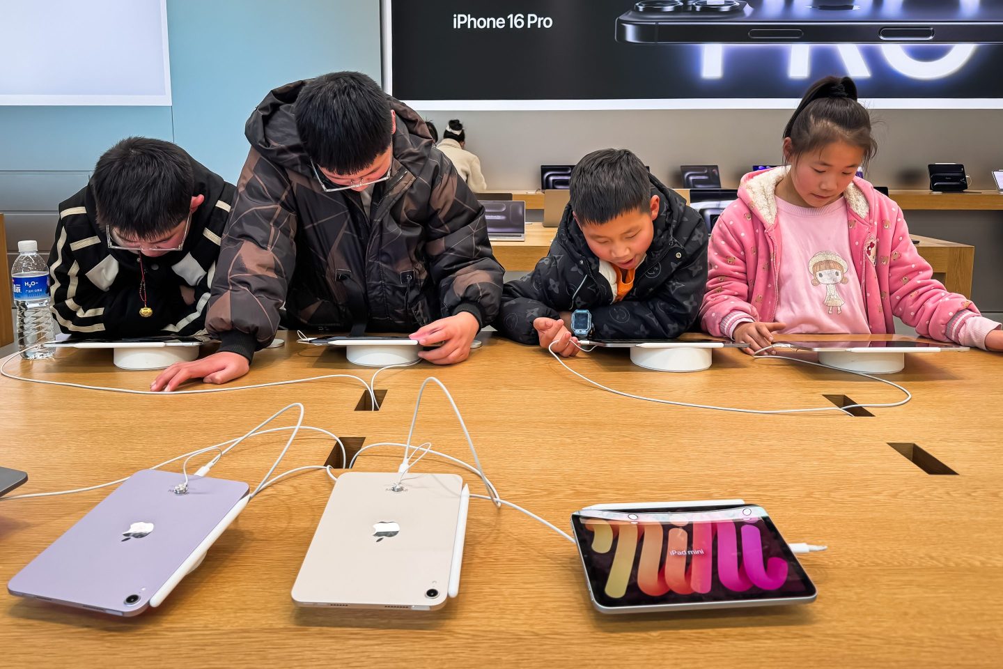 Children interact with iPads at an Apple Store, sitting at a wooden table equipped with the latest devices, including the iPad mini and iPad Air, on Jan. 26, 2025, in Chongqing, China.