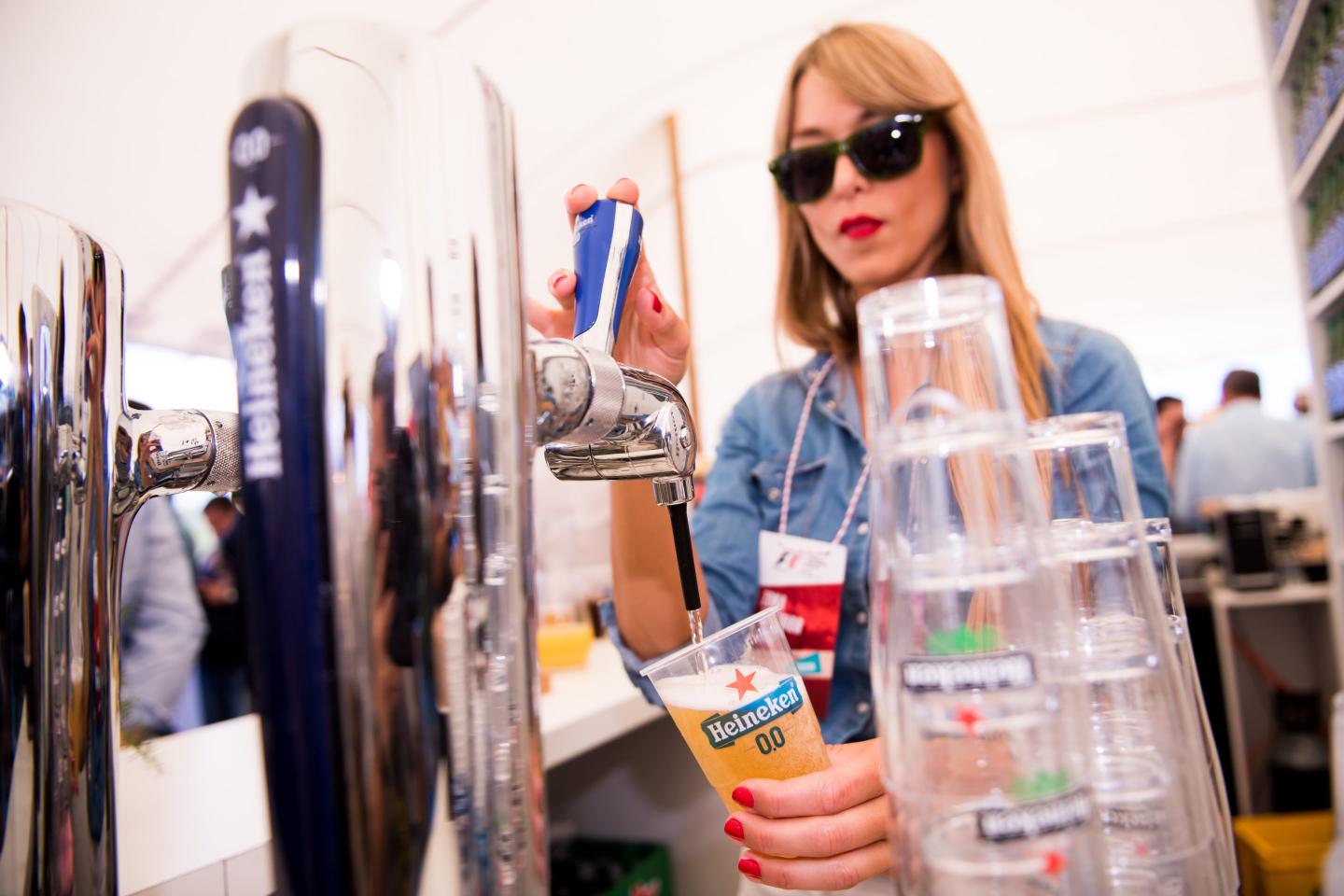 person pouring beer from a tap