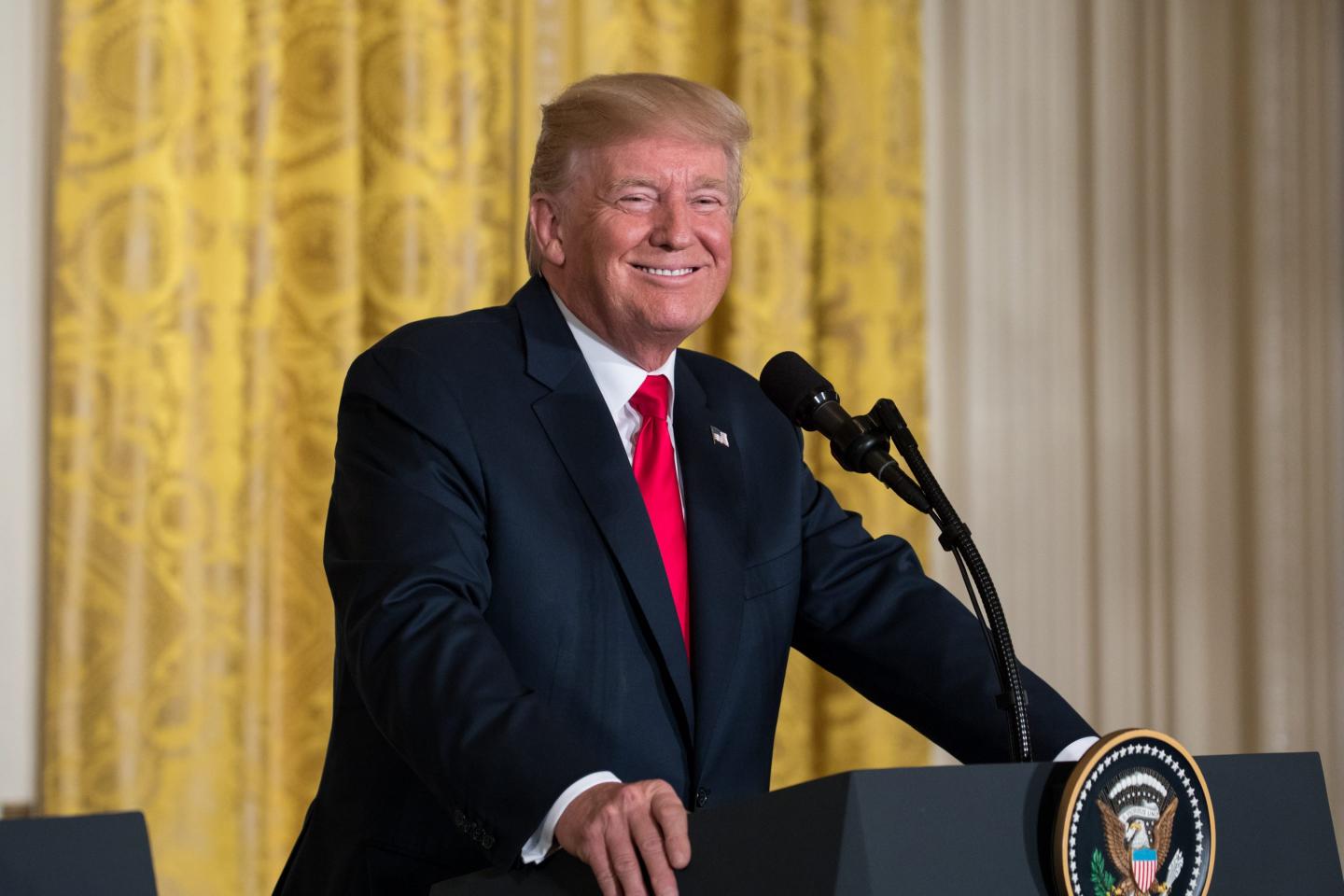 U.S. President Donald Trump laughs during a press conference