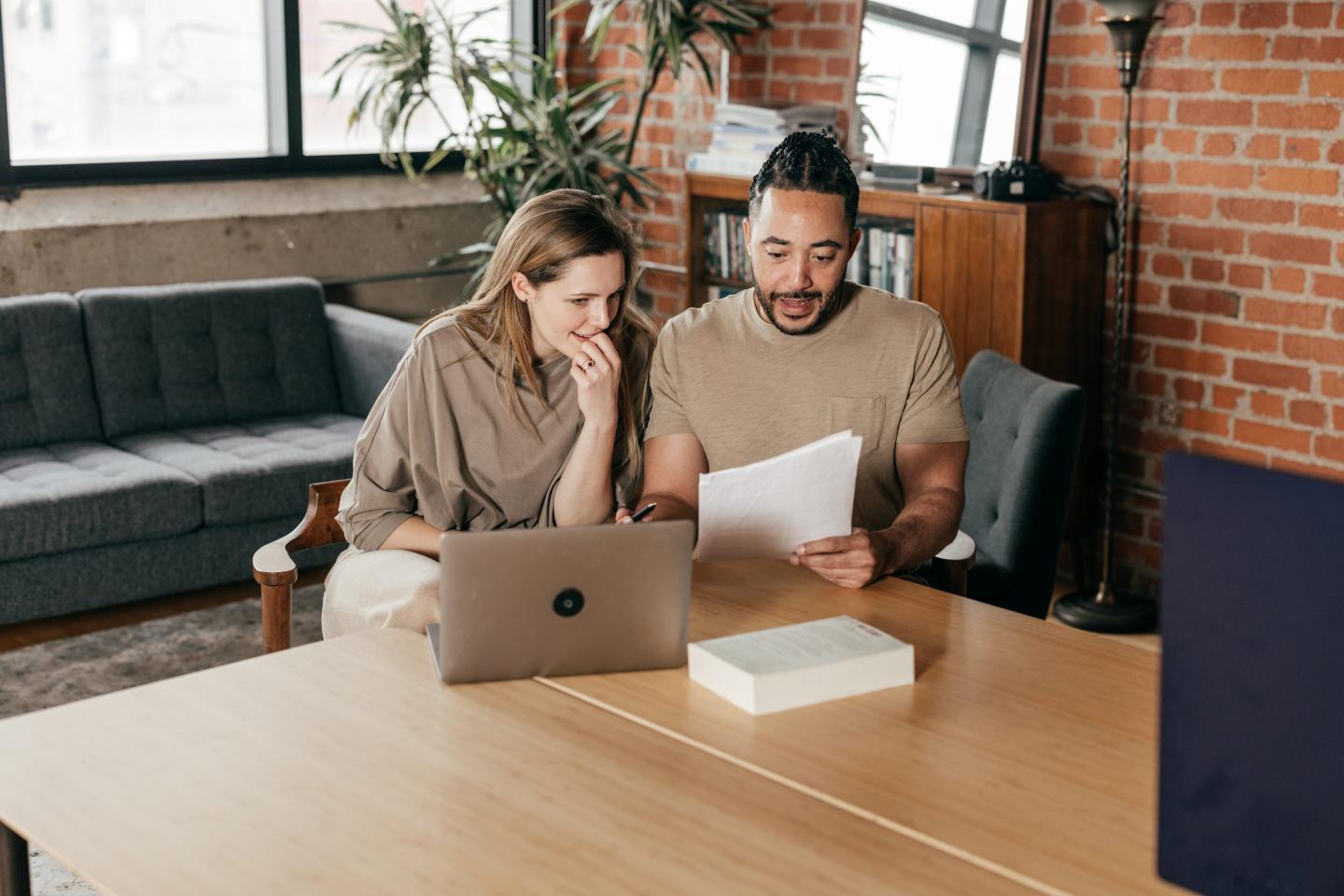 Two adults working on forms together.