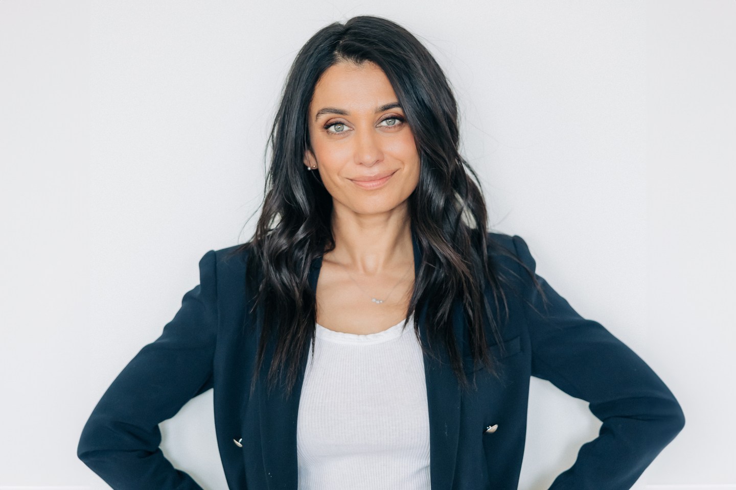 author Neha Ruch, with long dark hair and business professional attire