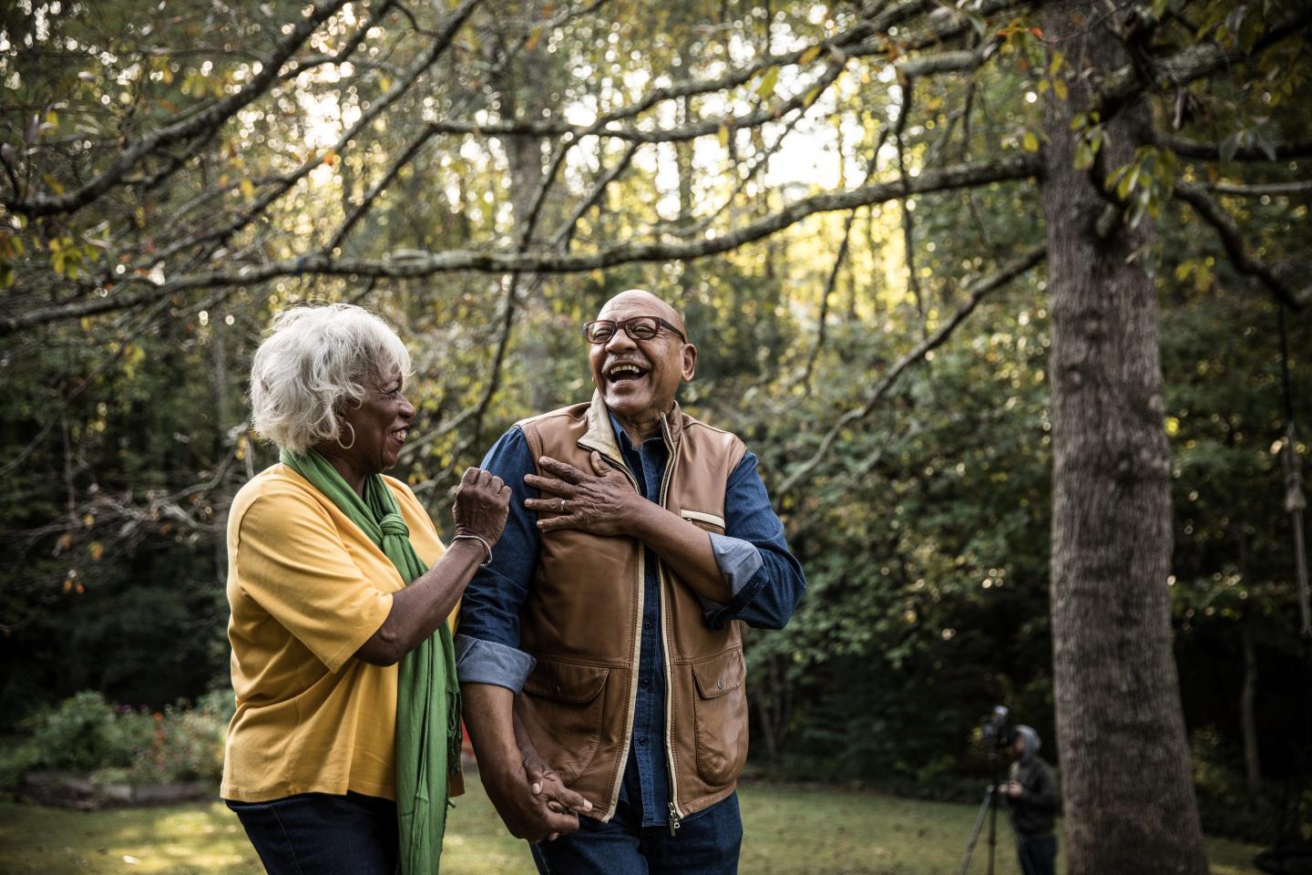 Two seniors walking through a field.