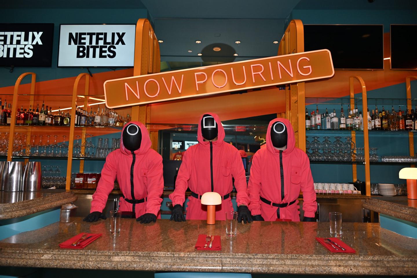 Waiters dressed in Squid Game costumes behind bar