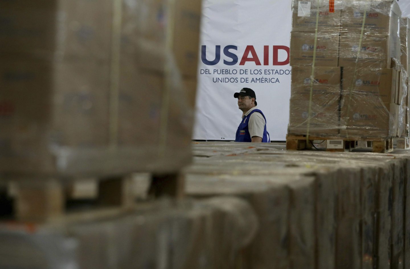A man walks past boxes of USAID humanitarian aid at a warehouse at the Tienditas International Bridge on the outskirts of Cucuta, Colombia, Feb. 21, 2019, on the border with Venezuela.