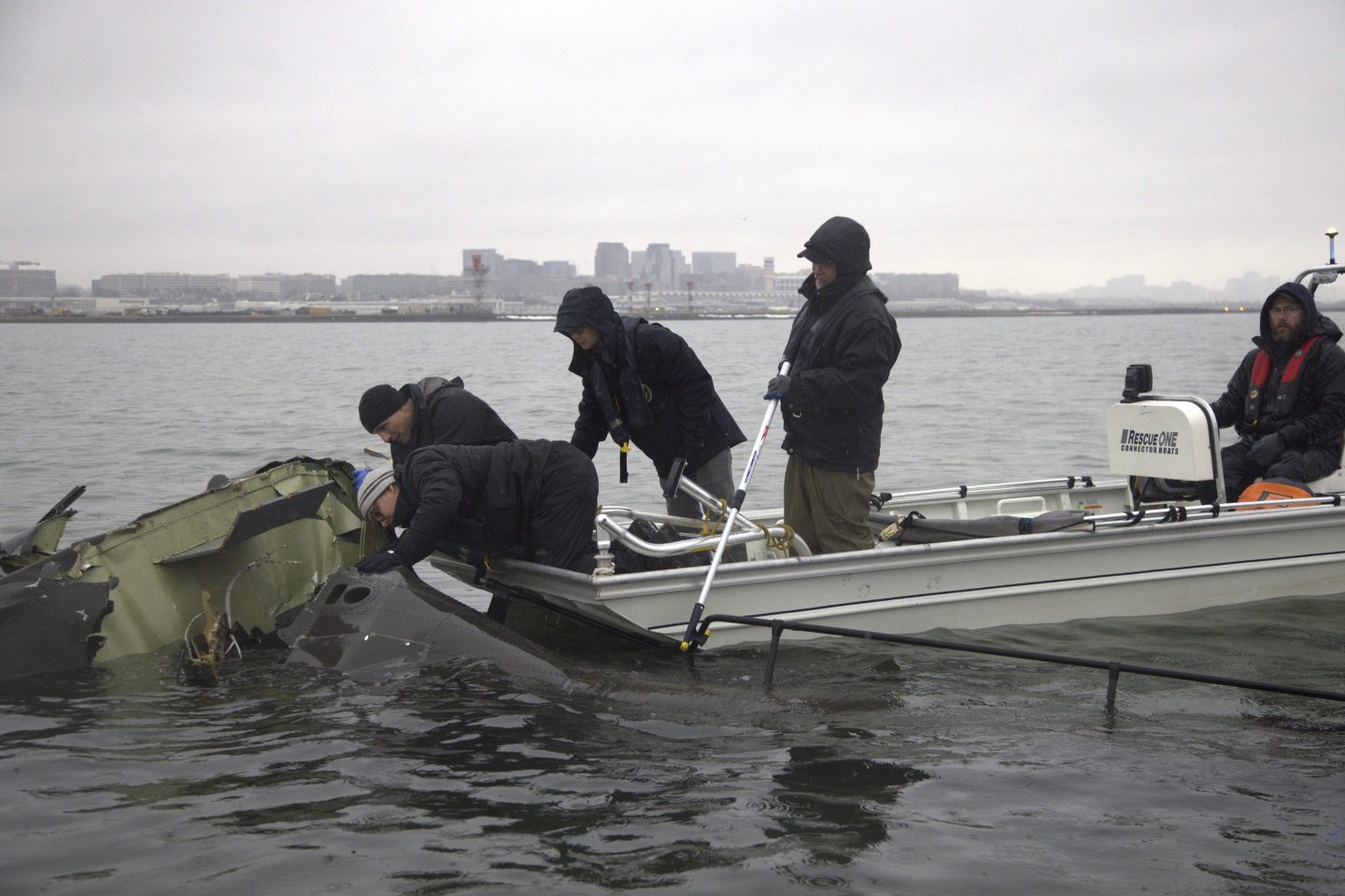 NTSB investigators and members of the salvage crew recover wreckage from the Army Black Hawk helicopter that collided with an American Airlines jet Wednesday night, Jan. 29, 2025, near Ronald Reagan Washington National Airport in Arlington, Va.