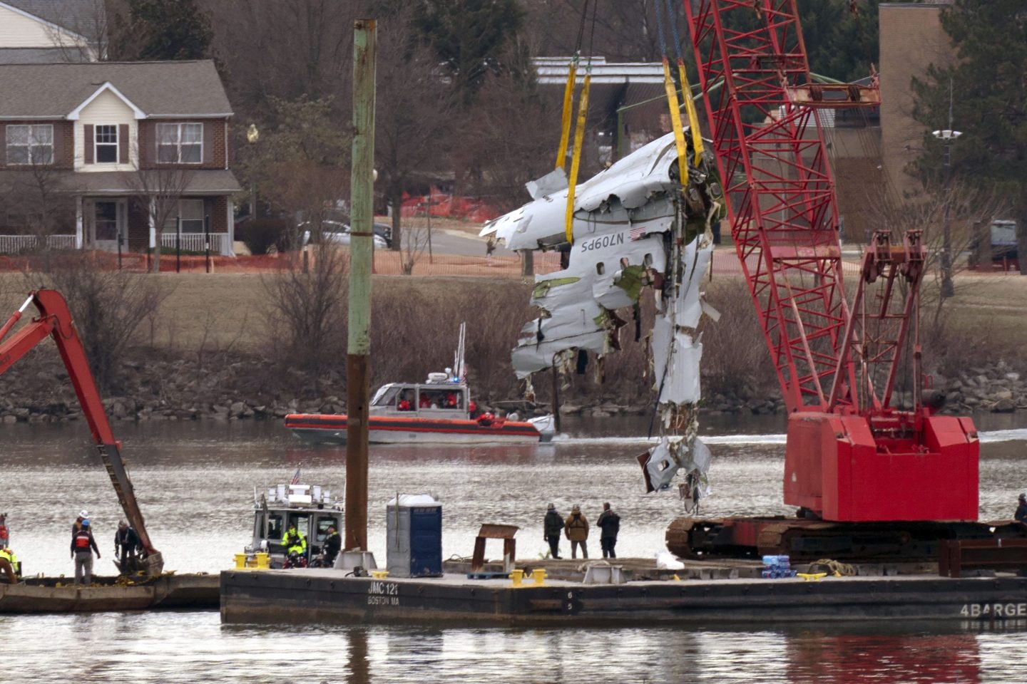 Rescue and salvage crews with cranes pull up the wreckage of an American Airlines jet in the Potomac River from Ronald Reagan Washington National Airport, on Feb. 3, 2025, in Arlington, Va.
