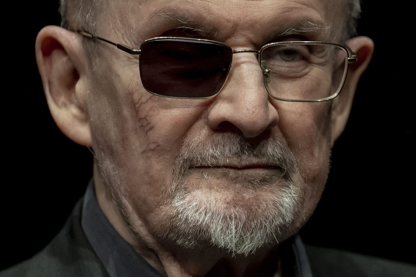 Salman Rushdie is pictured against a black background