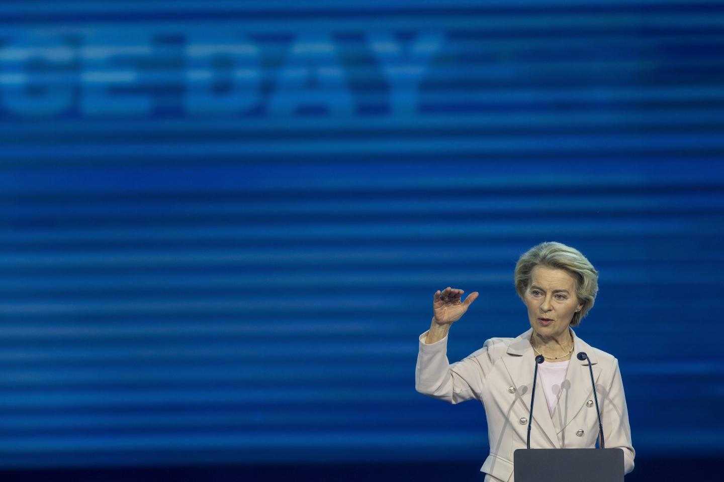 Ursula von der Leyen holds up her hand during a speech