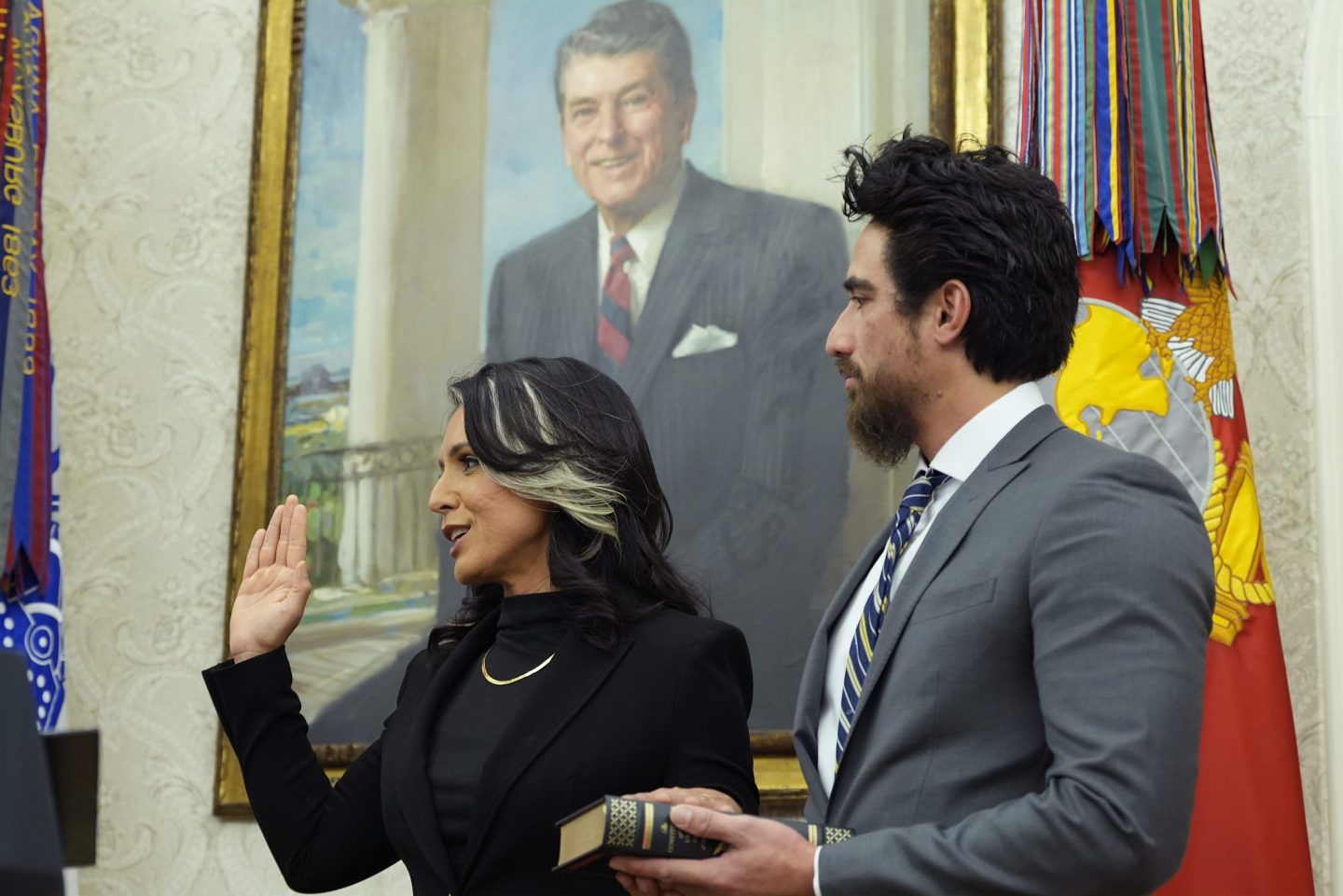Attorney General Pam Bondi swears in Tulsi Gabbard as the Director of National Intelligence in the Oval Office of the White House, Wednesday, Feb. 12, 2025, in Washington, as her husband Abraham Williams watches.