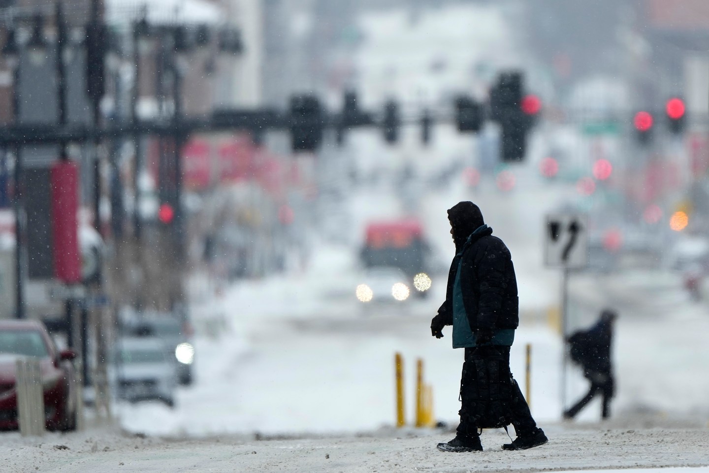 And there's snow too: Pedestrians cross a snowy street in downtown Kansas City, Mo., as a winter storm passed through the area on Feb. 12, 2025.