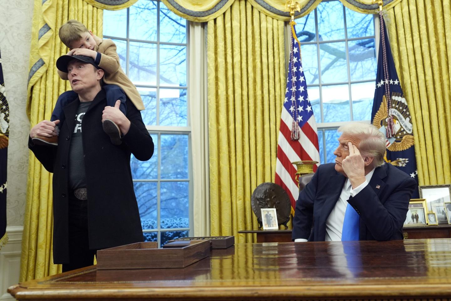 President Donald Trump listens as Elon Musk, joined by his son X Æ A-Xii, speaks in the Oval Office at the White House, Tuesday, Feb. 11, 2025, in Washington.