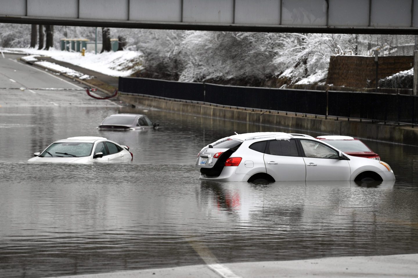 Cars sit in floodwaters at a railroad underpass in Louisville on Feb. 16, 2025.