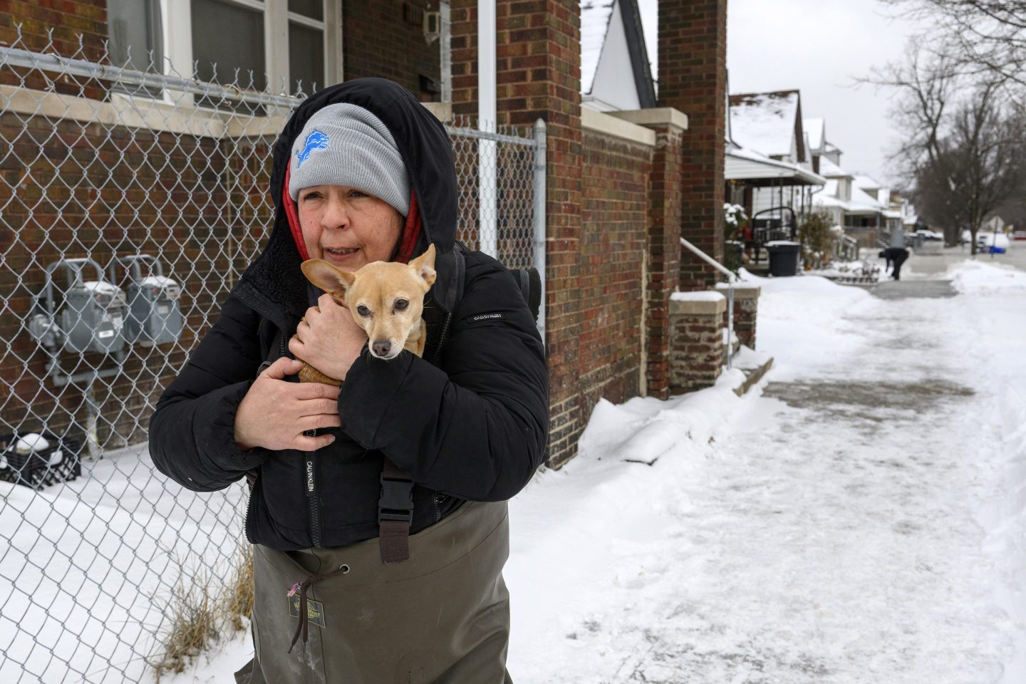 Lisa Muscat carries her dog Zoey to safety after a water main break in Detroit caused massive flooding, triggering evacuations, on Feb. 17, 2025.