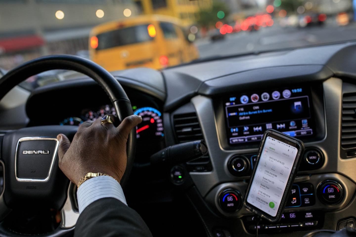 An Uber driver's hand on the steering wheel
