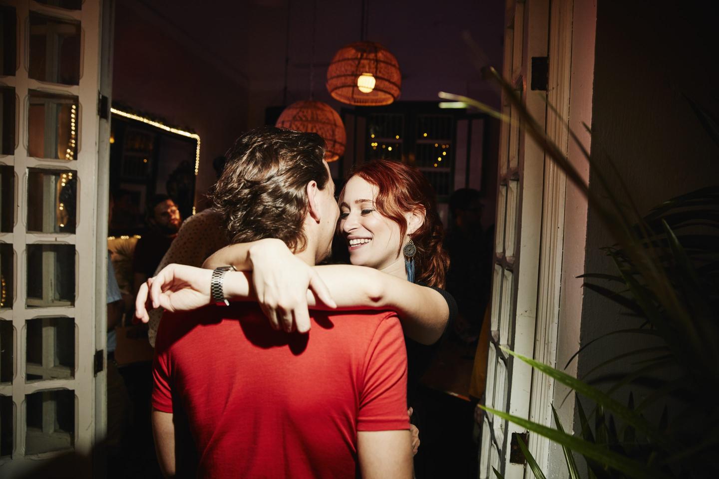 Gen Z couple embraces at party.