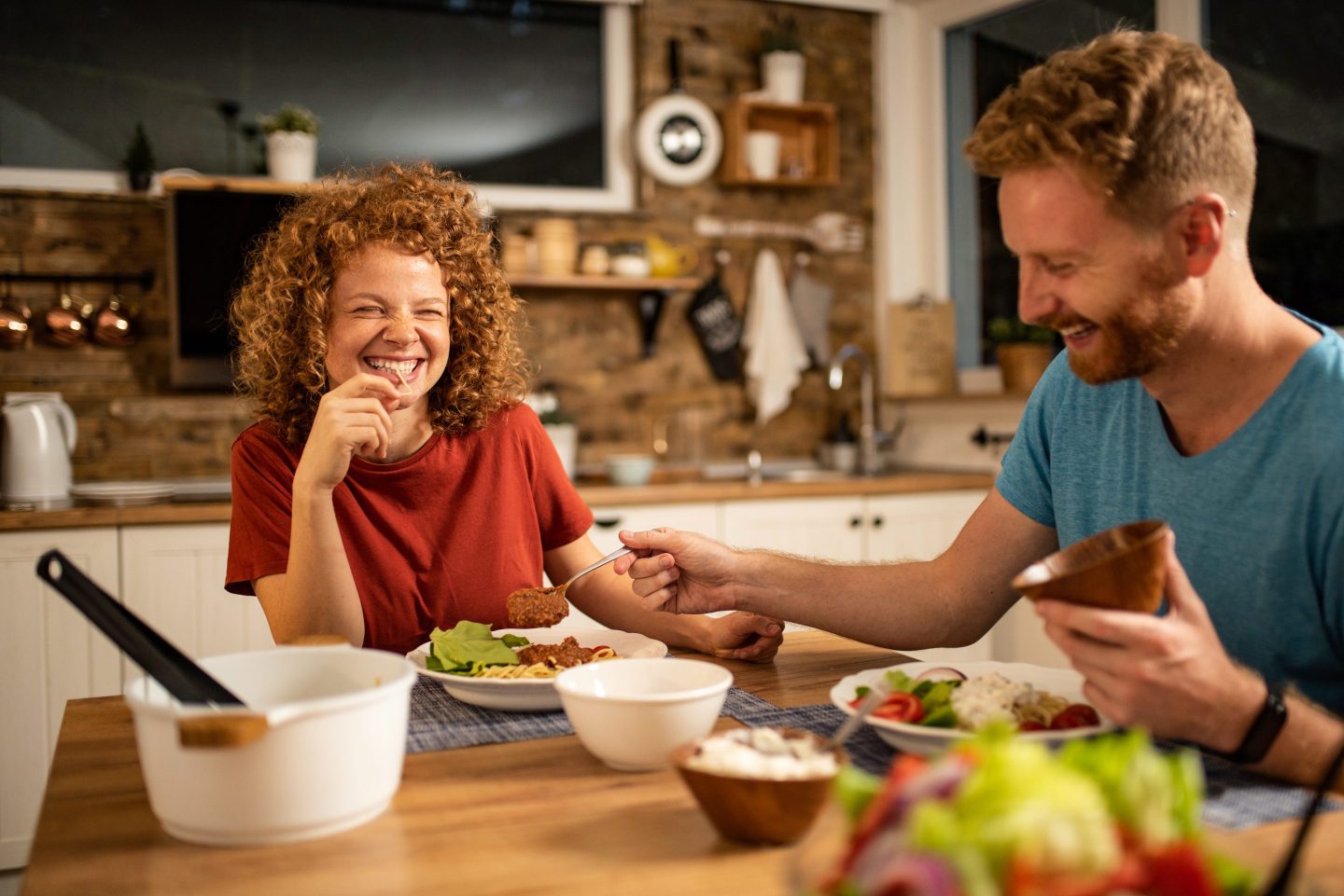 Two people eating a homemade meal.