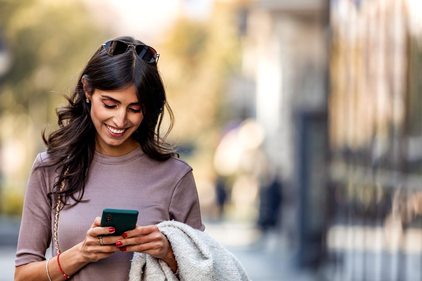 A person smiling and looking at their phone