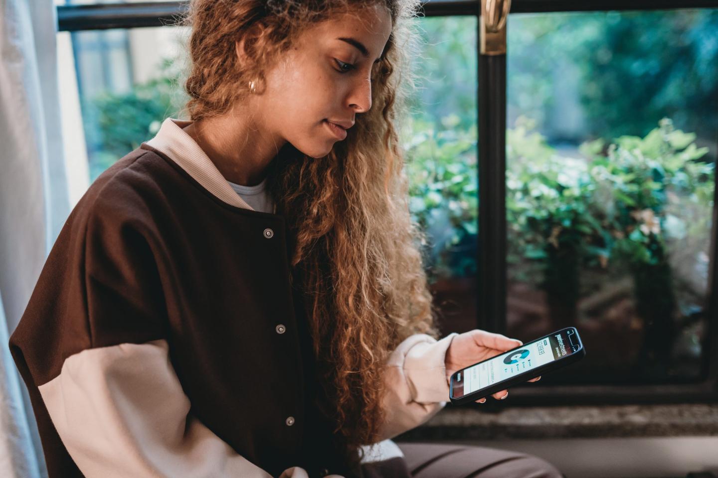 Gen Z checks bank accounts on phone.