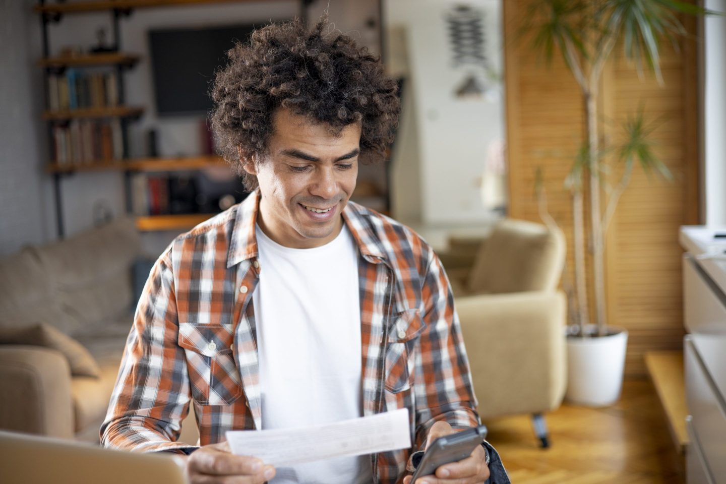 A person holding a piece of paper and a calculator.