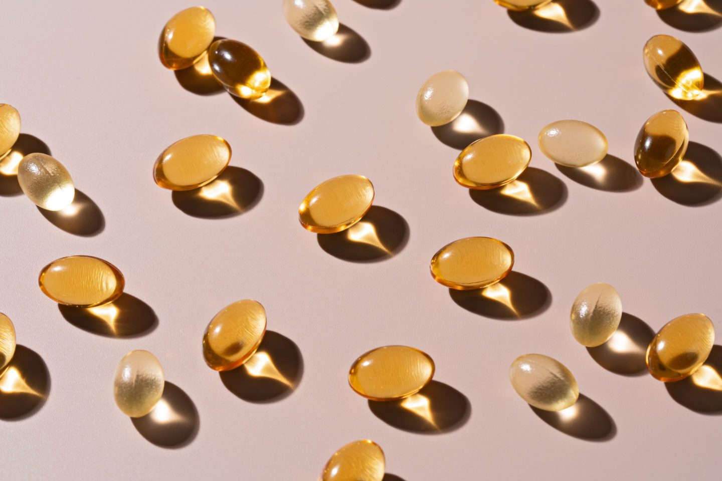 Gold Colored Soft Capsules on Beige Background