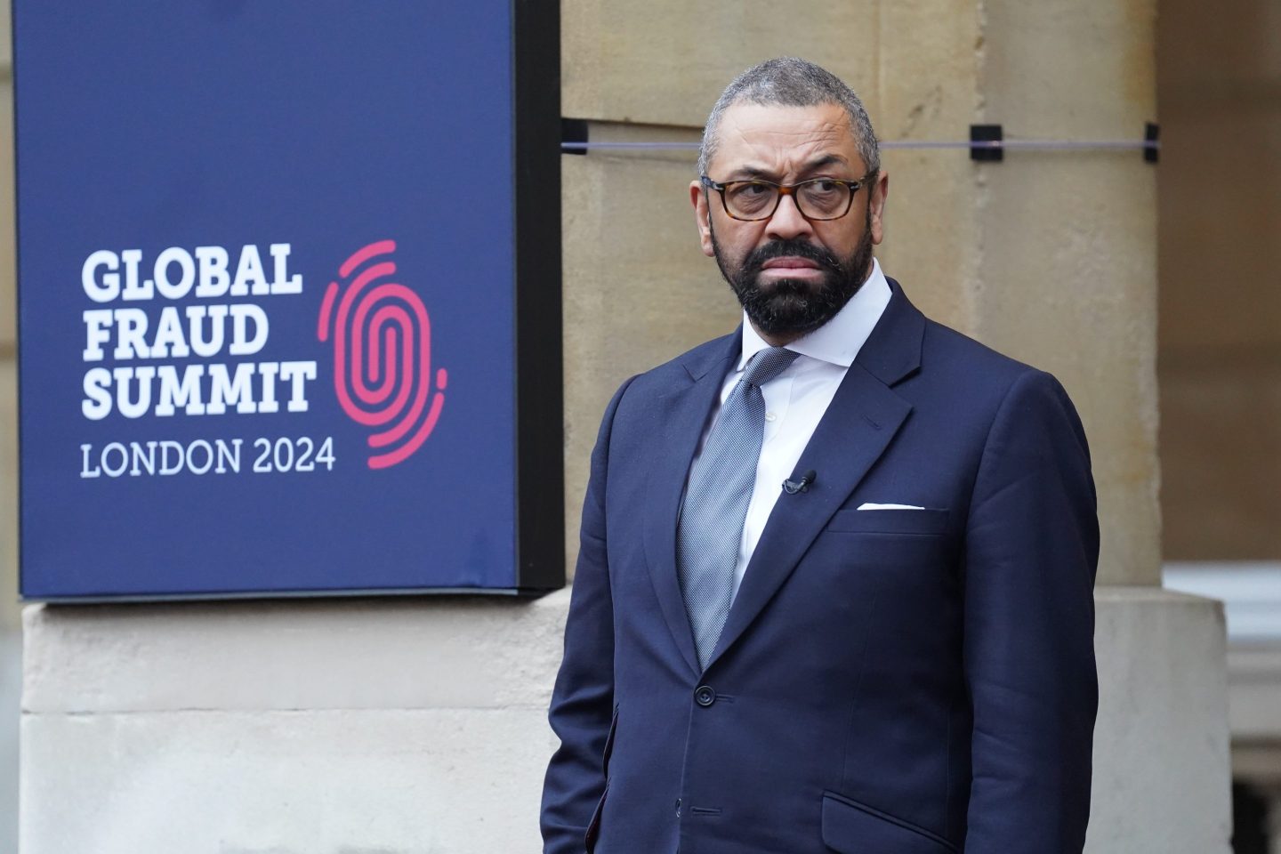 James Cleverly stands outside the Global Fraud Summit