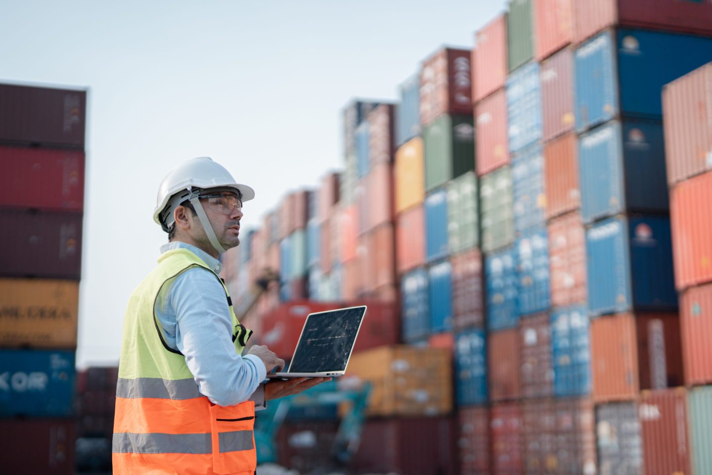Male engineer working at Containers yard. Cargo port storage for transportation and trading.