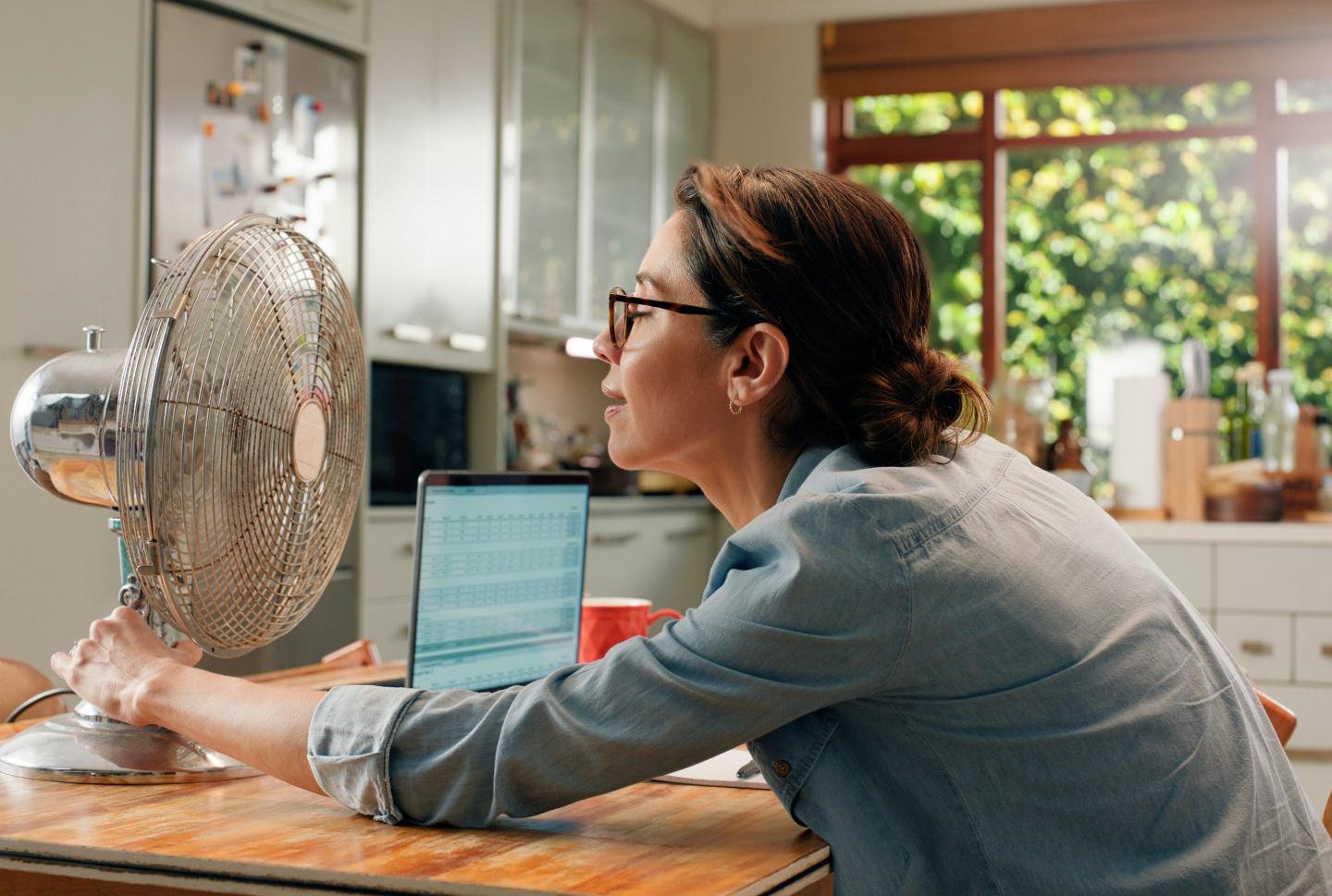 Woman sitting in front of fan