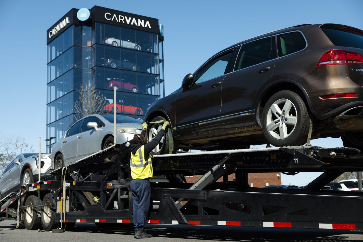 A man loads cars onto a transporter at a Carvana vending machine