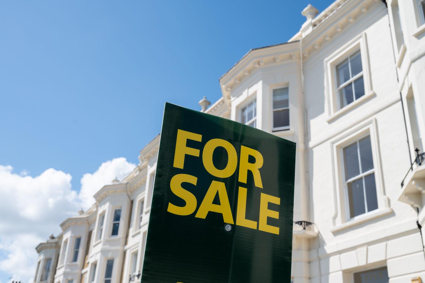 For Sale sign in front of townhomes.