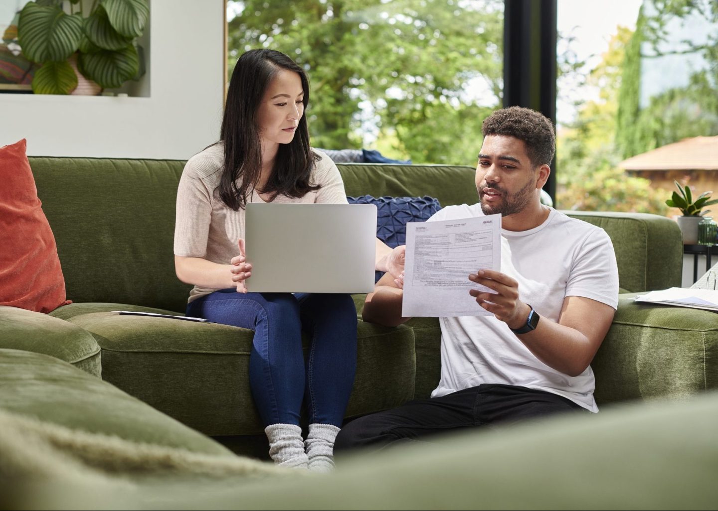 Two people going over forms on the couch.