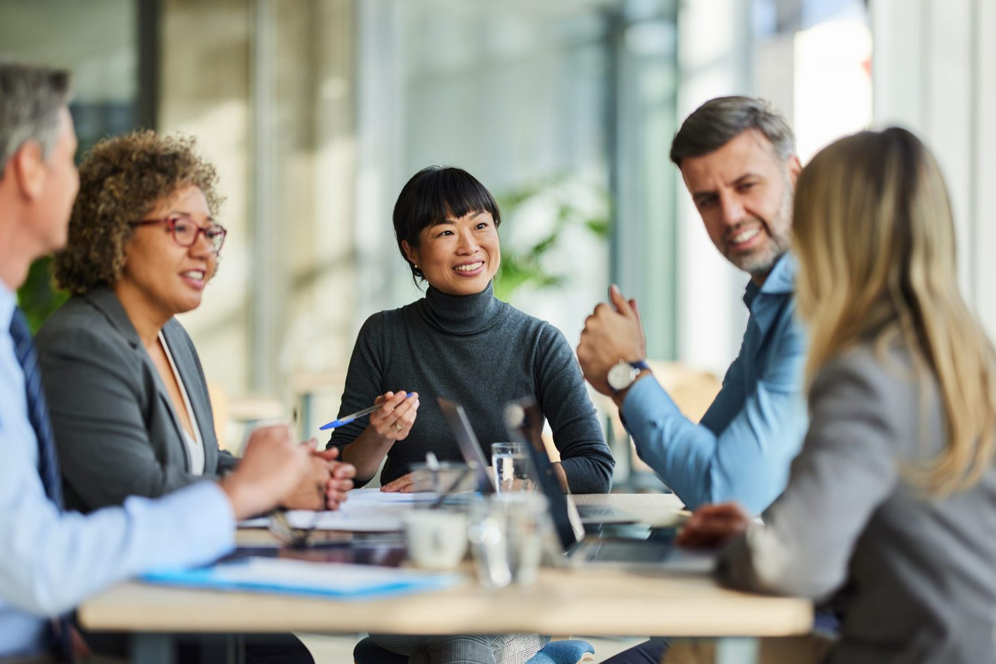 office workers communing in a meeting room, smiling and chatting