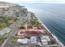 An aerial view of destroyed and cleared properties with vegetation regrowth on year after the Lahaina wildfire