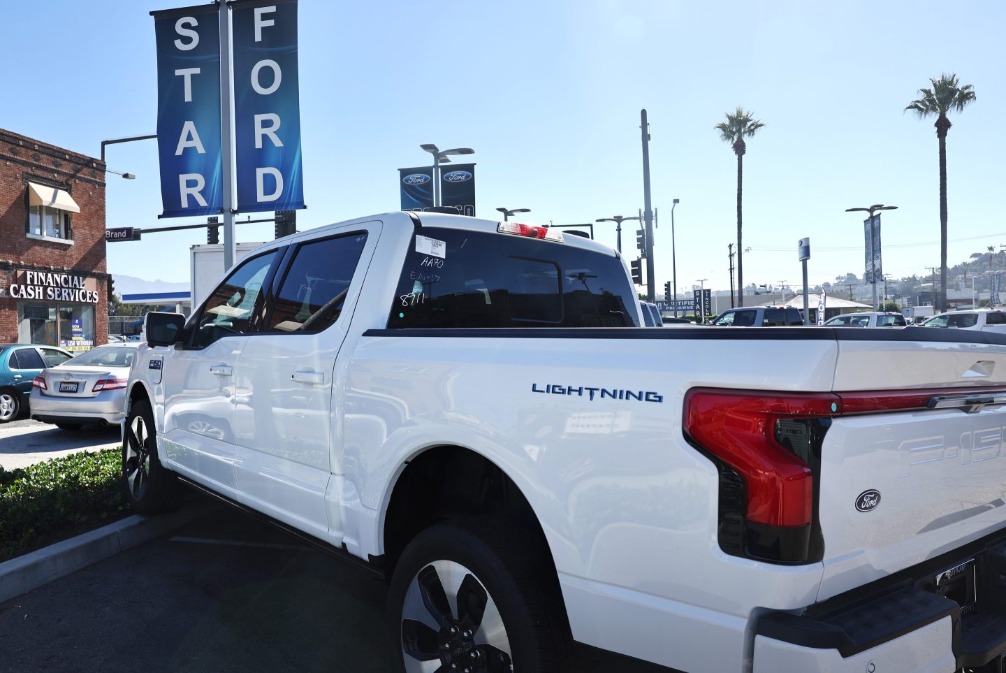 A Ford F-150 Lightning electric pickup truck is displayed for sale at a Ford dealership