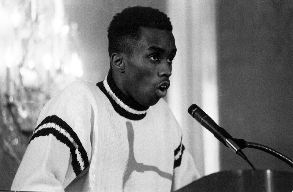 Sean Combs, with eyebrows raised, speaks into a microphone.