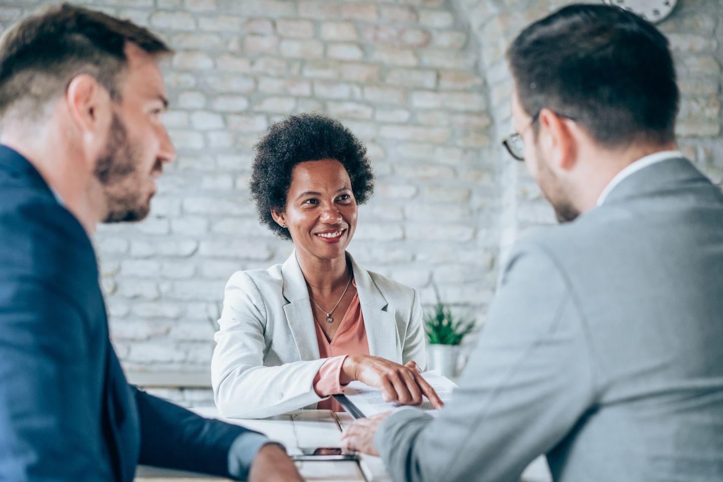 Business people shake hands while sitting down.