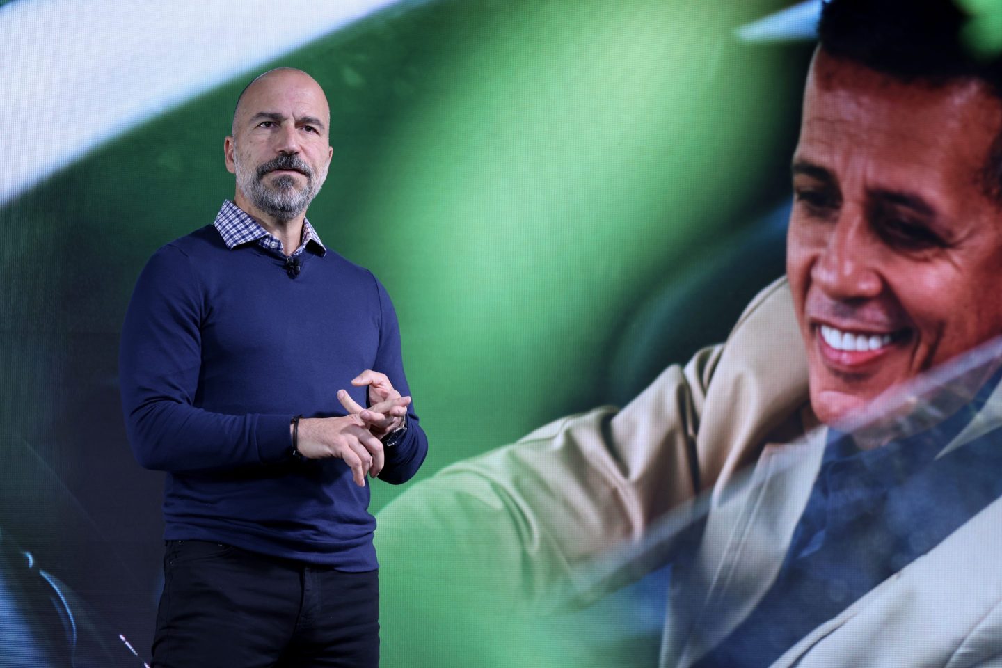 Uber CEO Dara Khosrowshahi giving a talk on a stage.