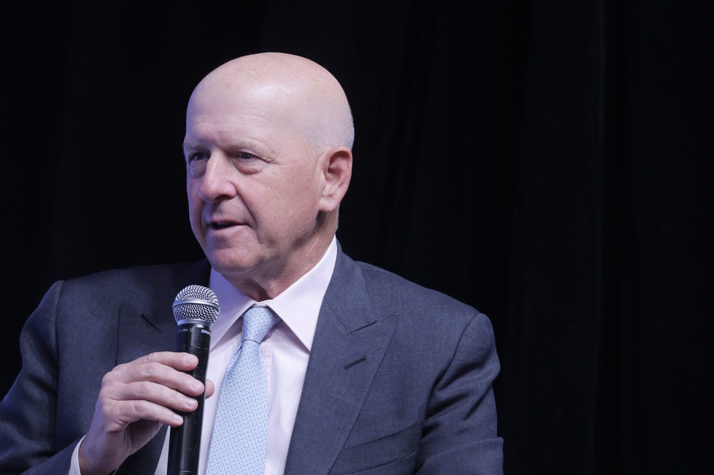 David Solomon in a suit and tie speaking into a microphone