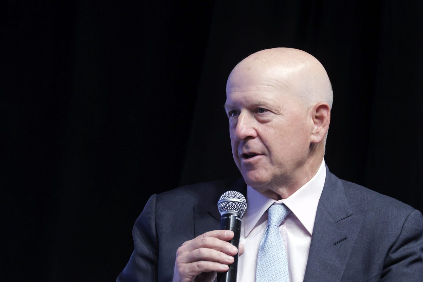 Goldman Sachs CEO David Solmon holds a microphone