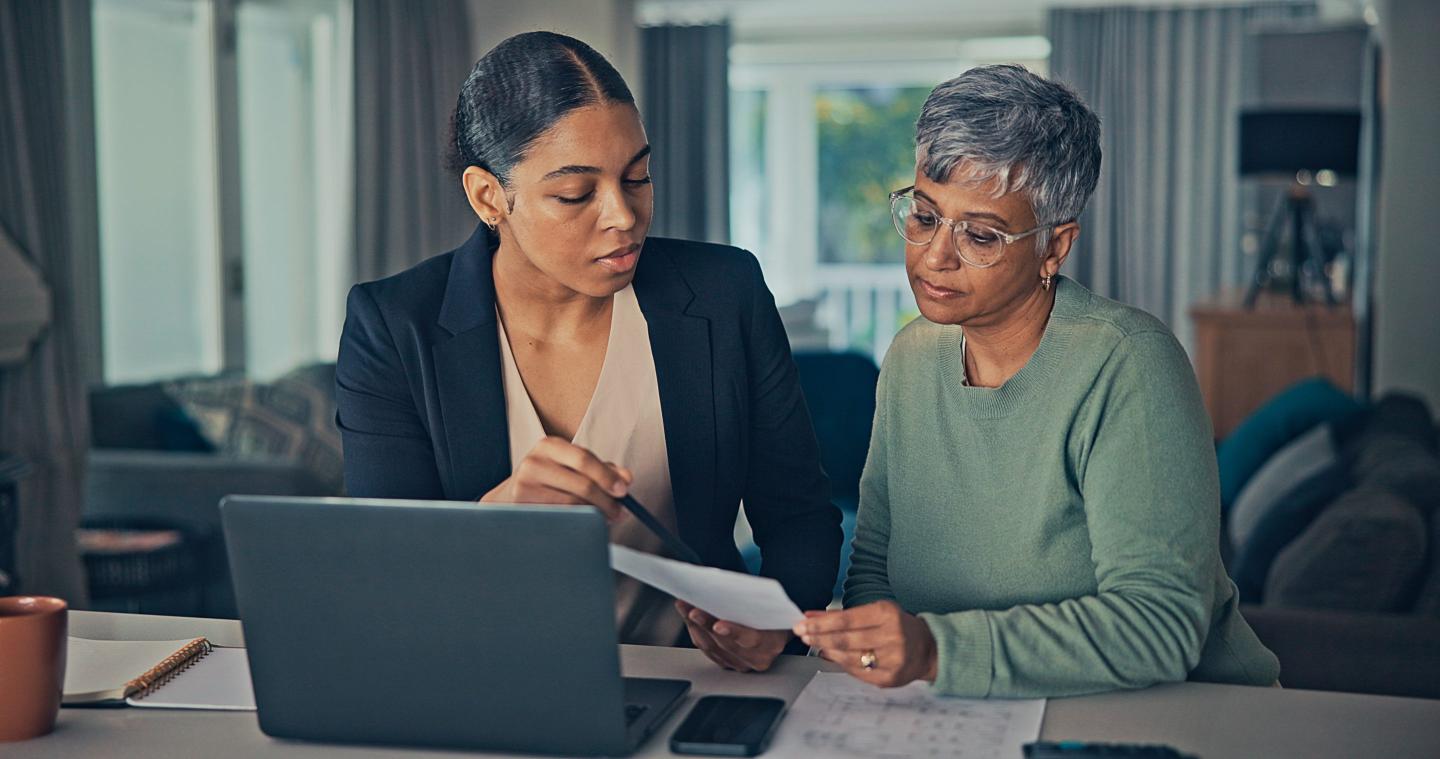A person going over forms with someone else at a table.